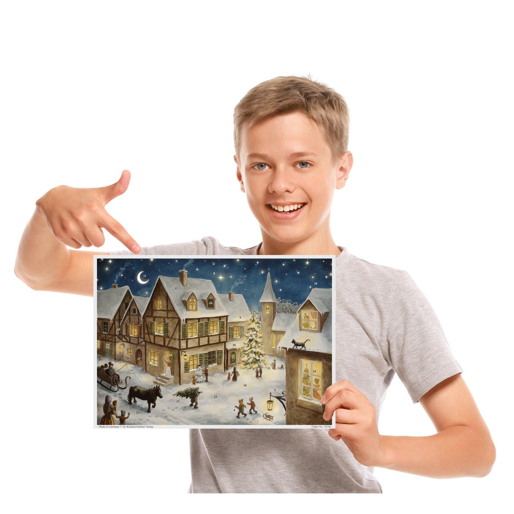 Kind mit Adventskalender "Weihnachtsabend im Dorf"  in der Hand. thumbnail